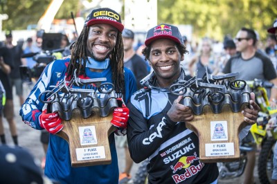 Two event champions with metal trophies